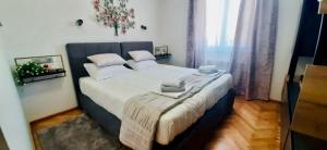 een slaapkamer met een groot bed met witte lakens bij Villa EVAMAR, Island Krk Punat in Punat