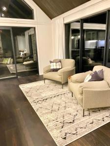a living room with two chairs and a rug at Luxury Alpine Retreat with a hot tub in Frankton