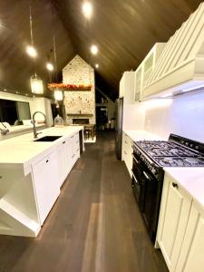 a kitchen with white cabinets and a stove top oven at Luxury Alpine Retreat with a hot tub in Frankton