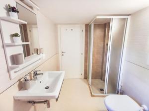 La salle de bains blanche est pourvue d'un lavabo et d'une douche. dans l'établissement Casa Chiara in centro con corte privata, à San Benedetto del Tronto