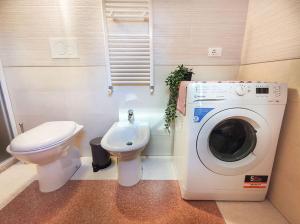 Un baño con lavadora y un inodoro. en Casa Chiara in centro con corte privata, en San Benedetto del Tronto
