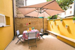 - une table et un parasol sur la terrasse dans l'établissement Casa Chiara in centro con corte privata, à San Benedetto del Tronto