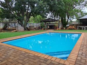 a large blue swimming pool in a yard at Vosloo's rest in Vereeniging