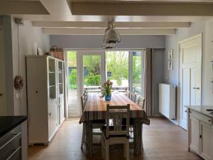 a dining room with a table and chairs in a kitchen at Charmant vakantiehuis op unieke locatie in Groede