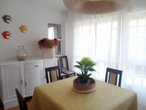 a dining room with a table with a plant on it at Casa Amelia 1ªP a 50 m Camino de Santiago in Padrón