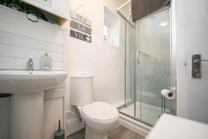a bathroom with a toilet and a sink and a shower at Beautiful Victorian Apartment in Clacton-on-Sea