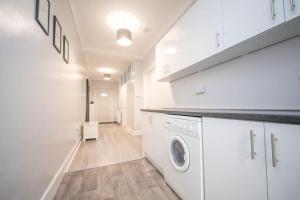 a white laundry room with a washer and dryer at Beautiful Victorian Apartment in Clacton-on-Sea