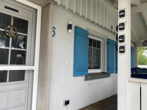 eine Eingangstür eines Hauses mit blauen Fensterläden in der Unterkunft Ferienzimmer Oelhaf Zimmer in Rosé Self Check-In mit Key-Tresore in Wilhelmsdorf