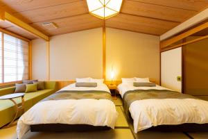 a room with two beds and a couch at Saginoyusou in Yasugi