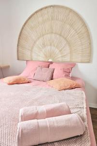 um quarto com uma cama grande e almofadas cor-de-rosa em L'atelier, T3 central, calme et charme em Vincennes
