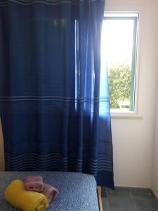 バレストラーテにあるLa Casa sul Mare - Marinaioのベッドルーム(青いカーテン、窓付)