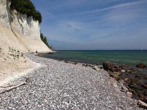 a rocky beach next to the ocean with a cliff at Fürstenhof - Ferienwohnung 104 in Sassnitz