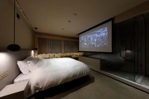 a bedroom with a large bed and a flat screen tv at HotelCO Kuramae ホテル コ 蔵前 in Tokyo