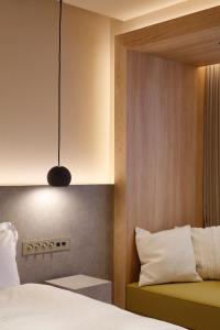 um quarto com uma cama e uma luz pendente em HotelCO Kuramae ホテル コ 蔵前 em Tóquio