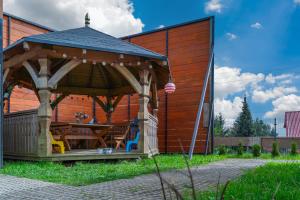 a wooden gazebo with a table in it at Domek wczasowy z dostępem do Mini zoo Donkeyszot 