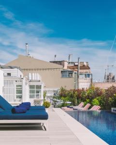 a swimming pool with a blue couch on a balcony at Seventy Barcelona in Barcelona +50 photos
