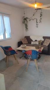 een woonkamer met een tafel en 2 stoelen bij Studio avec entrée indépendante in Montbozon