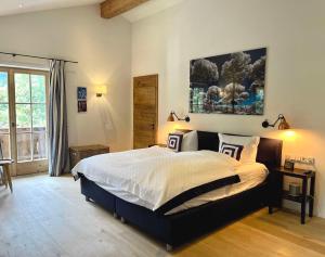 a bedroom with a large bed and a large window at Landhaus Riedlern - Exklusives Ferienhaus in Kreuth am Tegernsee in Kreuth