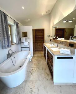 a large bathroom with a tub and two sinks at Landhaus Riedlern - Exklusives Ferienhaus in Kreuth am Tegernsee in Kreuth +23 photos