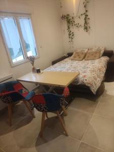 1 dormitorio con 1 cama, mesa y sillas en Studio avec entrée indépendante en Montbozon