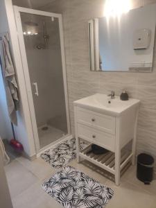 een badkamer met een witte wastafel en een spiegel bij Studio avec entrée indépendante in Montbozon