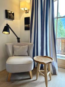 a chair and a table in a room with a window at Landhaus Riedlern - Exklusives Ferienhaus in Kreuth am Tegernsee in Kreuth