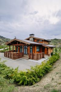 una casa con un gran porche en un campo en Le Chalet by Amirsoy en Chimgan