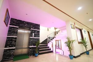 a lobby with a staircase and a wall with plants at The Crown Hotel in Tājganj