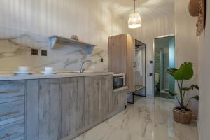 a kitchen with wooden cabinets and a sink and a potted plant at Irene's House Kalamitsi in Kalamitsi