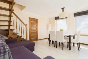 a kitchen and dining room with a table and chairs at Holiday House BURSZTYN - Nature, Relax & Terrace by Noclegi Renters in Kołczewo