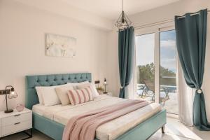 sypialnia z dużym łóżkiem i balkonem w obiekcie Defamelia Villa w mieście Kefalonia