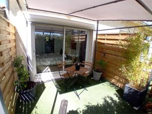 een open patio met een tafel en een hek bij Domaine Le Clos Lassagne in Brignais