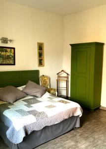 1 dormitorio con cama y puerta verde en Chez Rosette de Lussan, en Lussan