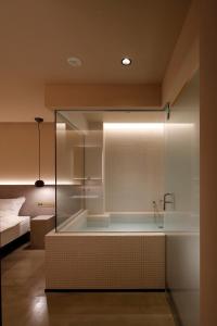 東京的住宿－HotelCO Kuramae ホテル コ 蔵前，一间设有床铺的客房内的玻璃淋浴间