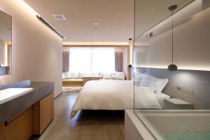 a bedroom with a bed with a glass wall at HotelCO Kuramae ホテル コ 蔵前 in Tokyo