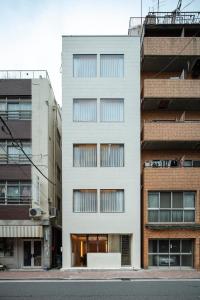 um edifício branco numa rua da cidade com edifícios em HotelCO Kuramae ホテル コ 蔵前 em Tóquio