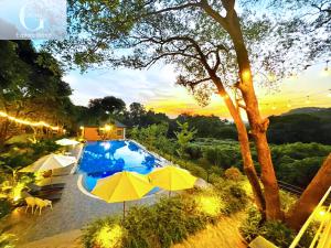 einen Blick über einen Pool mit Sonnenschirm in der Unterkunft Cerf Volant Resort in Hanoi