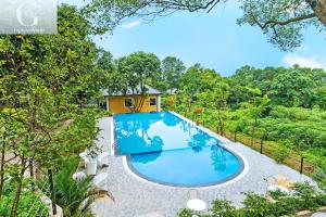 an image of a swimming pool in front of a house at Cerf Volant Soc Son Resort in Hanoi