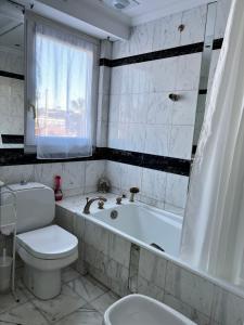 a bathroom with a tub and a toilet and a sink at Le palais napoleon in Golfe-Juan