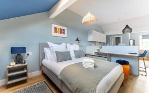 een slaapkamer met een groot bed en een blauwe muur bij Swallow in Bowness-on-Windermere