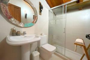 a bathroom with a sink and a toilet and a mirror at Acogedor chalet adosado con entrada independiente in Lamadrid