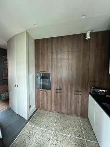 a kitchen with wooden cabinets and a microwave at HYPER CENTRE, logement climatisé avec PARKING SECURISE in Clermont-Ferrand