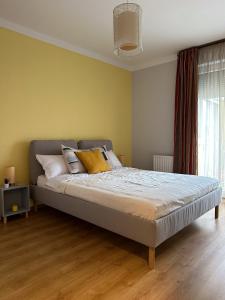 um quarto com uma cama grande e paredes amarelas em Cherry Abode Apartment with Terrace em Budapeste