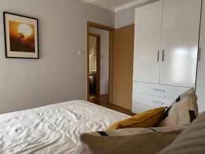um quarto com uma cama branca e um armário em Cherry Abode Apartment with Terrace em Budapeste