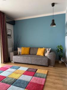 uma sala de estar com um sofá e um tapete colorido em Cherry Abode Apartment with Terrace em Budapeste