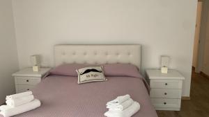 Apartment with a garden في ليدو دي فينيتسا: غرفة نوم بسرير عليها مناشف وكيس