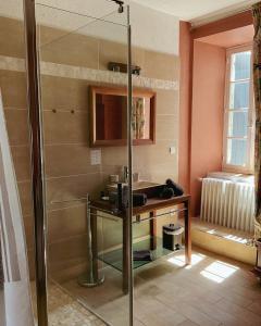 a bathroom with a shower with a table and a sink at Chez Rosette de Lussan in Lussan