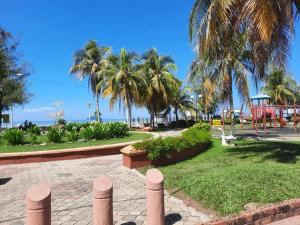 een park met palmbomen en een speeltuin bij Kesuma Homestay Pantai Murni in Yan