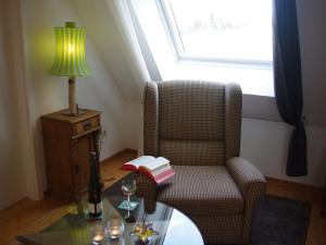 a living room with a chair and a table with a lamp at Schmitzebrinks Ferienwohnung in Kierspe