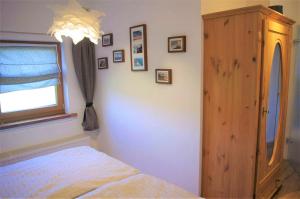 ein Schlafzimmer mit einem Bett, einer Kommode und einem Fenster in der Unterkunft Schmitzebrinks Ferienwohnung in Kierspe
